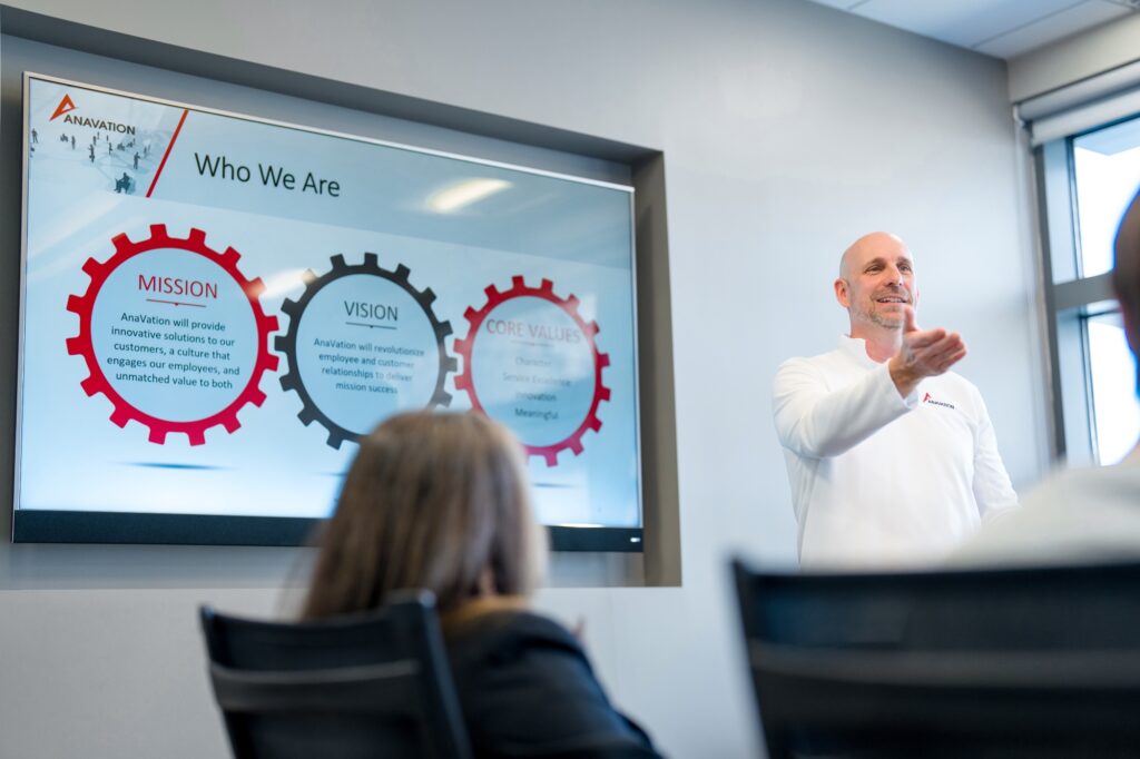 Staff in a meeting standing in front a whiteboard